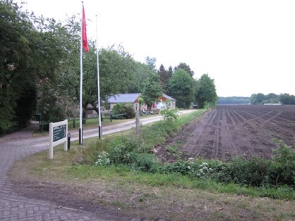 De ingang van Camping De Tol met de vlag en het Commissaris Cramerpad